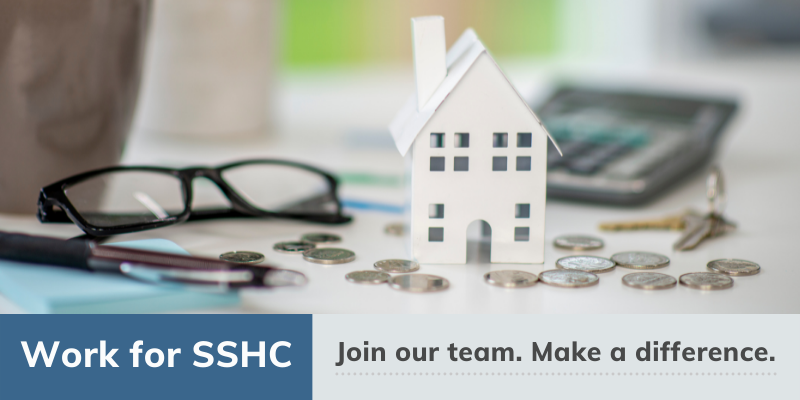 Work for SSHC. Join our team. Make a Difference. Image of a work desk with a small house, calculator, and change